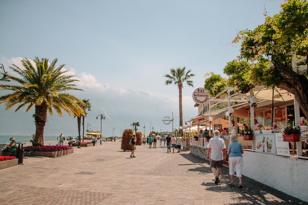 Walking along the promenade lined with restaurants on one side and the lake on the other in Limone, Lake Garda